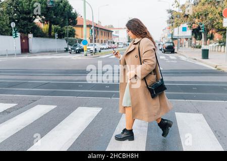 Femme de taille plus qui utilise un smartphone lors de son passage à la route Banque D'Images