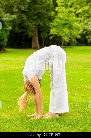 Young woman doing yoga in park Banque D'Images