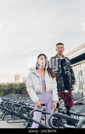 Jeune couple debout à la station de parking pour vélos Banque D'Images