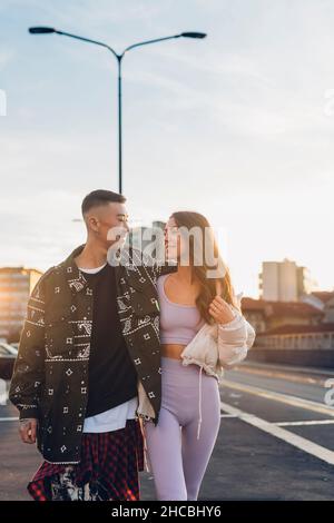 Couple romantique regardant les uns les autres et marchant sur la route Banque D'Images