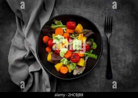 Studio de prise d'un bol de salade végétalienne avec des légumes cuits au four Banque D'Images