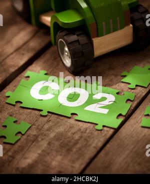 CO2 pièces de puzzle par voiture-jouet sur table Banque D'Images