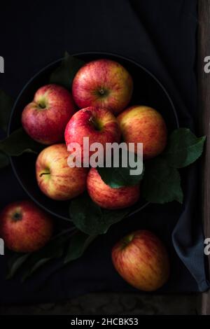 Photo de studio de la pomme de Gala fraîche à moitié couchée sur le dessus du tapis de place plié Banque D'Images