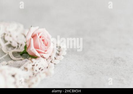 Studio de roses roses, tulle brodée et petite boîte avec anneau d'engagement plat posé sur fond blanc Banque D'Images