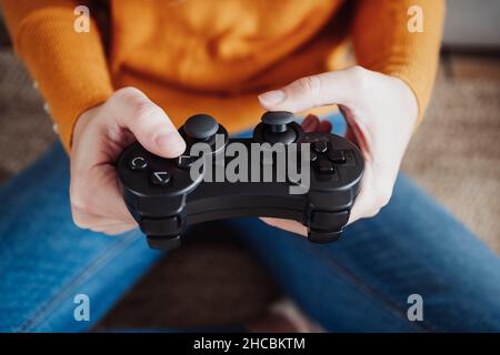 Jeune femme tenant une manette de jeu à la maison Banque D'Images