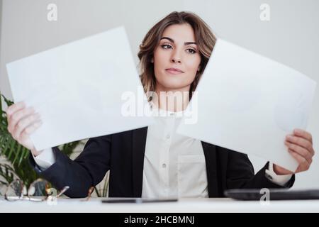 Une jeune femme d'affaires examine les rapports au bureau Banque D'Images