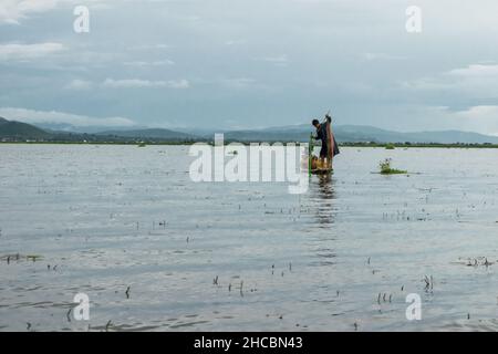 Un birman, à la pointe du bateau ou du kayak, pêchant avec des filets et manvolant son bateau au lac Inle Banque D'Images