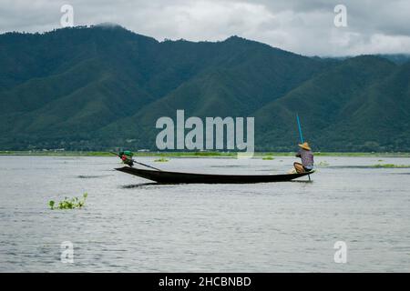 Un birman, à la pointe du bateau ou du kayak, pêchant avec des filets et manvolant son bateau au lac Inle Banque D'Images