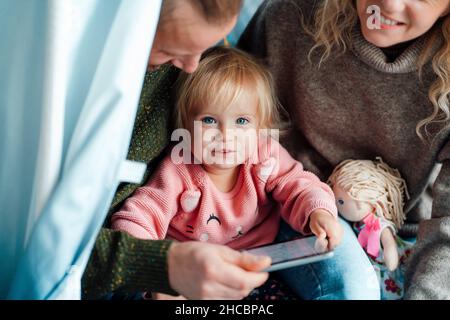 Famille utilisant une tablette PC dans une tente à la maison Banque D'Images