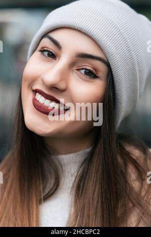 Belle femme souriante portant un chapeau en tricot Banque D'Images