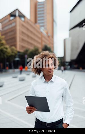 Homme d'affaires souriant utilisant une tablette PC sur la place Banque D'Images