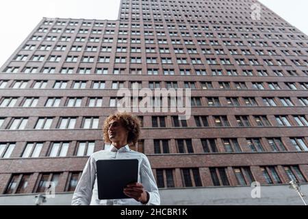 Homme d'affaires confiant avec armes croisées à la Potsdamer Platz Banque D'Images