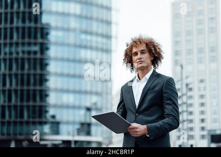 Homme d'affaires avec une tablette PC dansant en ville Banque D'Images