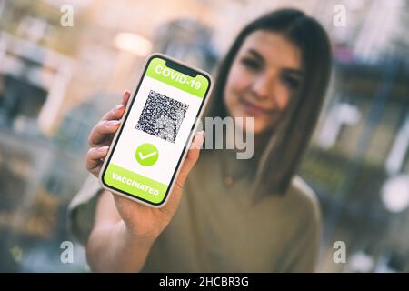 Femme présentant un certificat de vaccination numérique COVID-19 sur l'écran du téléphone portable Banque D'Images