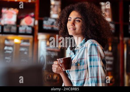 Propriétaire attentionné tenant une tasse de café à la maîtrise Banque D'Images