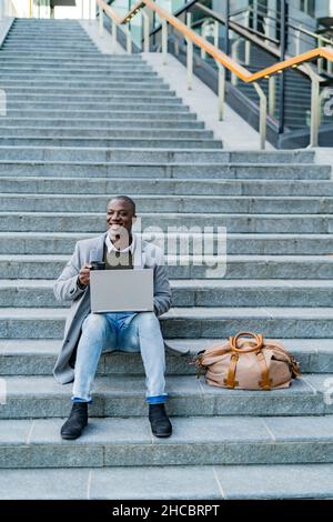 Homme d'affaires avec ordinateur portable assis sur des marches Banque D'Images