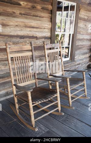 Deux fauteuils à bascule en bois sur le porche d'une cabane en bois au Heritage Village, dans les jardins botaniques de Floride à Largo, en Floride. Banque D'Images