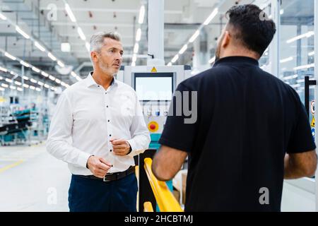 Homme d'affaires discutant avec un ingénieur de maintenance de l'industrie électrique Banque D'Images