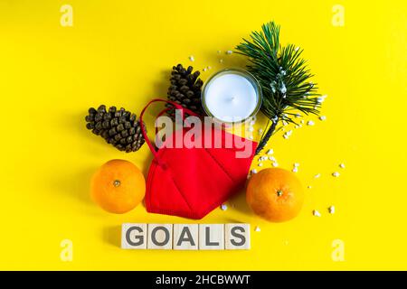 Les mandarines sont dans le masque médical parmi les branches de l'arbre de Noël, mot objectifs cubes en bois Banque D'Images