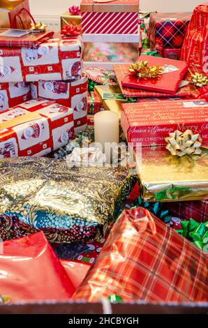 Piles de cadeaux de Noël, soigneusement enveloppées dans du papier de fête et décorées de boucles et de rubans. Banque D'Images