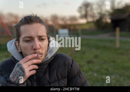 Woodbridge Suffolk Royaume-Uni Mars 01 2020: Un 20 quelque chose d'homme fume un joint de cannabis pour aider à sa santé.Médecine alternative, marijuana médicale con Banque D'Images