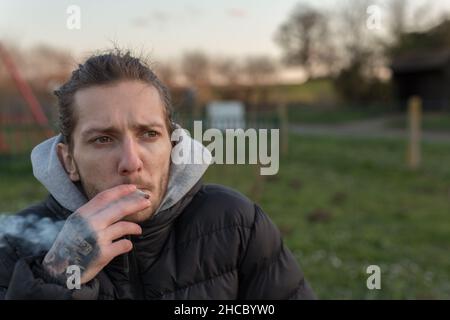 Woodbridge Suffolk Royaume-Uni Mars 01 2020: Un 20 quelque chose d'homme fume un joint de cannabis pour aider à sa santé.Médecine alternative, marijuana médicale con Banque D'Images