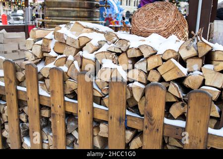 Le bois haché dans une pile de bois se trouve derrière la clôture Banque D'Images