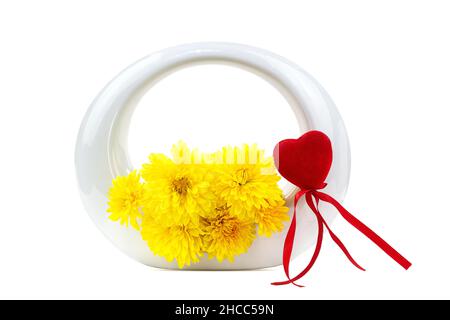 Fleurs de chrysanthème jaune dans un vase rond avec coeur rouge sur fond blanc isolé.Saint-Valentin, Fête des mères, Journée internationale de la femme, anniversaire.Co Banque D'Images