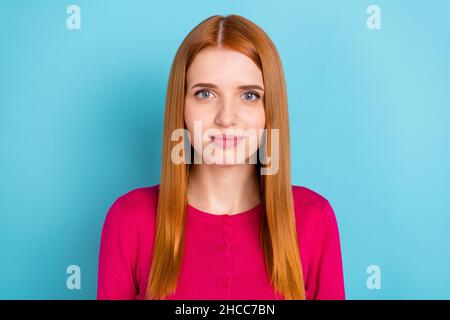 Portrait de contenu attrayant fille à cheveux rouges portant un pull-over rose isolé sur fond bleu vif Banque D'Images