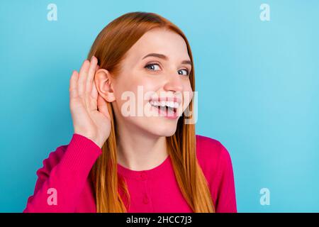 Photo de brillant curieux jeune femme porter chemise rose bras oreille écouter secrets sourire isolé couleur bleu fond Banque D'Images