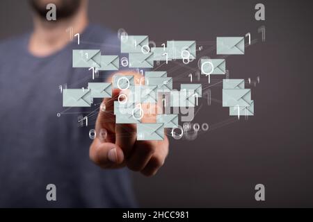 Gros plan de la main pointant vers les icônes flottantes d'e-mail avec des nombres binaires. Banque D'Images