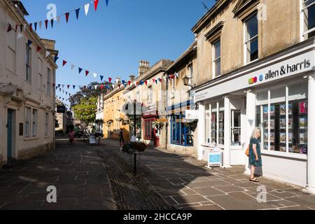 Les boutiques sont décorées de banderoles et de paniers de fleurs sur la traditionnelle High Street de Corsham dans le Wiltshire. Banque D'Images