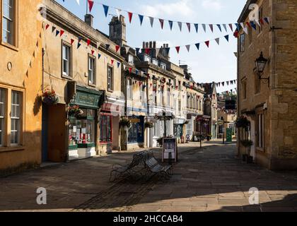 Les boutiques et les bureaux sont décorés de banderoles et de paniers de fleurs sur la traditionnelle High Street de Corsham dans le Wiltshire. Banque D'Images