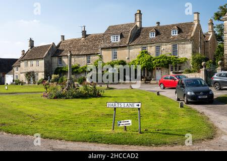 Des maisons et des cottages traditionnels en pierre sont aménagés autour du village vert de Biddestone, dans les Cotswold Hills d'Angleterre. Banque D'Images