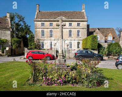 Des maisons et des cottages traditionnels en pierre sont aménagés autour du village de Biddestone et du mémorial de guerre dans les Cotswold Hills d'Angleterre. Banque D'Images