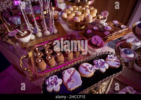 Une table de banquet avec canapés et gâteaux joliment décorés, prête pour un événement Banque D'Images