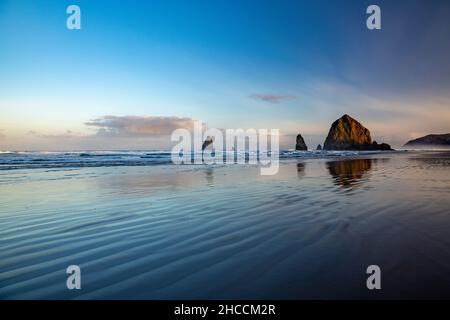 Haystack Rock reflétée sur l'eau et de rides, Cannon Beach Oregon, USA Banque D'Images