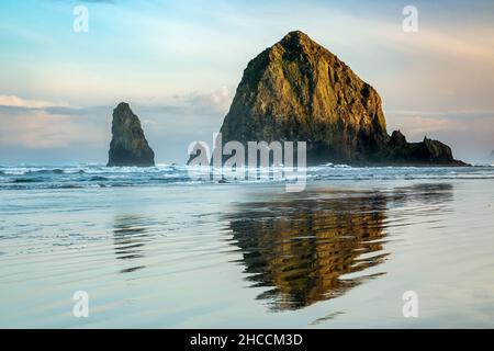 Haystack Rock reflétée sur l'eau et de rides, Cannon Beach Oregon, USA Banque D'Images