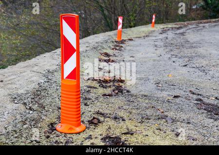 Virage à droite, des panneaux de signalisation protecteurs se trouvent sur une route de montagne en virage Banque D'Images