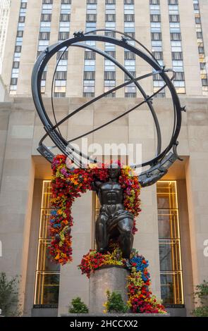 Sculpture d'Atlas avec guirlande de fleurs dans le Rockefeller Center Manhattan NYC Banque D'Images