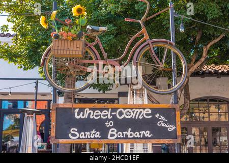 Un vélo suspendu au-dessus d'un panneau pour un nouveau restaurant. Banque D'Images