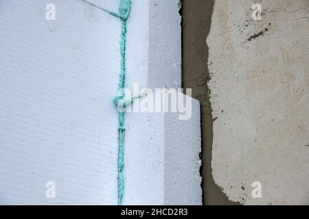 Installation de feuilles d'isolation en mousse de polystyrène sur le mur de la façade de la maison pour la protection thermique. Banque D'Images