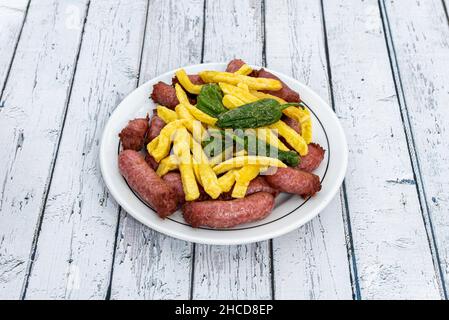 Saucisses de porc avec pommes de terre frites et poivrons padron frits Banque D'Images