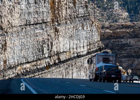 Les véhicules roulant dans une tranchée de route avec les couches de charbon sur la route 6 dans la région de Carbon County, Utah. Banque D'Images