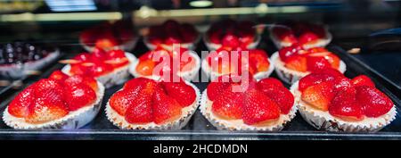 Gâteau exposé dans la vitrine de la boutique de confiserie ou de café.Des pâtisseries fraîches sont exposées dans une cabine de confiserie au célèbre marché de Granville à Vancouver Banque D'Images