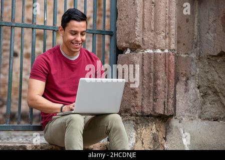 Jeunes latino hommes avec ordinateur portable dans la rue, Panama City, Amérique centrale Banque D'Images