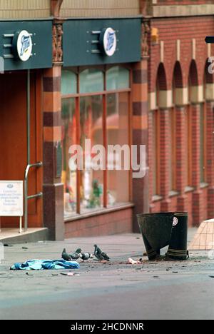 Photo du dossier datée du 20/03/93 de débris et de vêtements dispersés à l'extérieur du magasin Boots de Warrington après qu'une bombe a explosé dans un bac à litière.Date de publication : le mardi 28 décembre 2021. Banque D'Images