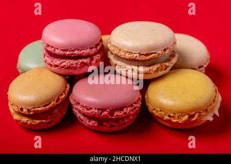 Macarons colorés sur fond rouge vif Banque D'Images