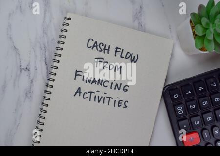 Flux de trésorerie provenant des activités de financement écrire sur un livre isolé sur une table en bois. Banque D'Images