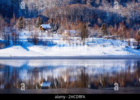 Petits chalets forestiers sur la rive du lac Poiana Marului pendant une journée d'hiver parfaite.Photo prise le 17th janvier 2021 dans la réserve de Poiana Marului, Banque D'Images